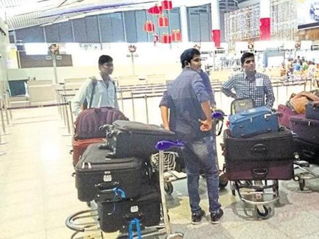 A group of students wait after being stopped at the Rajiv Gandhi International Airport in Hyderabad from boarding a US-bound flight on December 22.