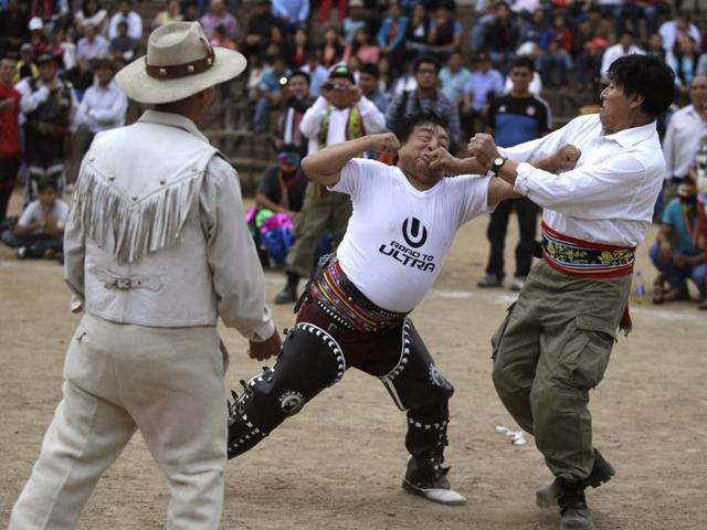 In this December 25, 2015 photo, Nestor Gabina (centre), fights his neighbour Gabriel Anaya during a ‘Takanakuy’ ritual fighting event on the outskirts of Lima, Peru on Christmas day. The long-time neighbours fought over the exact line between their properties, a dispute that has even been brought before the local courts. The fight lasted only a few minutes before the referee separated them without proclaiming an official winner. The men hugged and broke down in tears. Then they calmed the mix of adrenaline and shame with more beer. (AP) In this December 25, 2015 photo, Nestor Gabina (centre), fights his neighbour Gabriel Anaya during a ‘Takanakuy’ ritual fighting event on the outskirts of Lima, Peru on Christmas day. The long-time neighbours fought over the exact line between their properties, a dispute that has even been brought before the local courts. The fight lasted only a few minutes before the referee separated them without proclaiming an official winner. The men hugged and broke down in tears. Then they calmed the mix of adrenaline and shame with more beer. (AP)