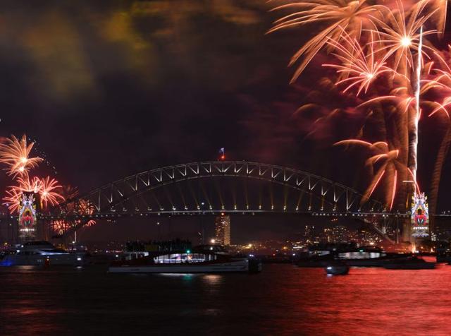 New Year's eve fireworks illuminate Sydney's iconic Harbour Bridge and Opera House during the traditional fireworks show held before the main midnight event on December 31, 2015. (AFP PHOTO / Peter PARKS)