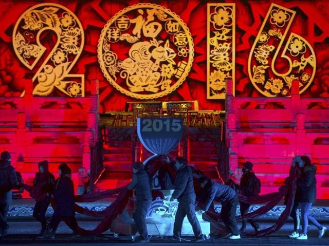 Workers push a 2016 countdown clock into position during a rehearsal for a New Year's eve countdown celebration at the Imperial Ancestral Temple in Beijing. At 8 hours ahead of Greenwich Mean Time, China will ring in 2016 ahead of much of the rest of the world on Thursday night. (AP Photo/Mark Schiefelbein)