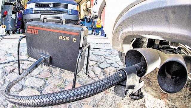 A measuring tube of an emissions testing device for diesel-powered vehicles is attached to the exhaust pipe of a Volkswagen diesel car in Germany (EPA File Photo)