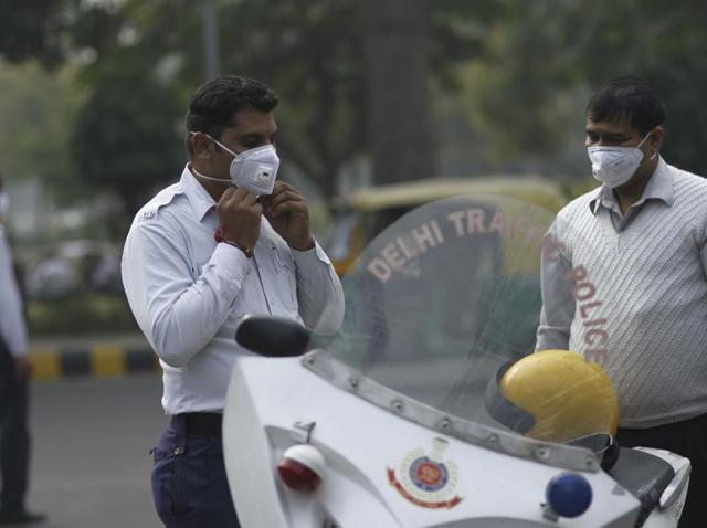 Masked policeman handles traffic at Janpath road. (Photo by Arun Sharma/ Hindustan Times)