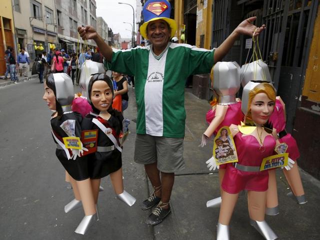 A man sells effigies of first lady Nadine Heredia and of Yahaira, a dancer and girlfriend of Peru's soccer player Jefferson Farfan, in a market in Lima, Peru. Peruvians traditionally burn effigies of popular figures from the past year as part of New Year's celebrations. (REUTERS/Mariana Bazo)