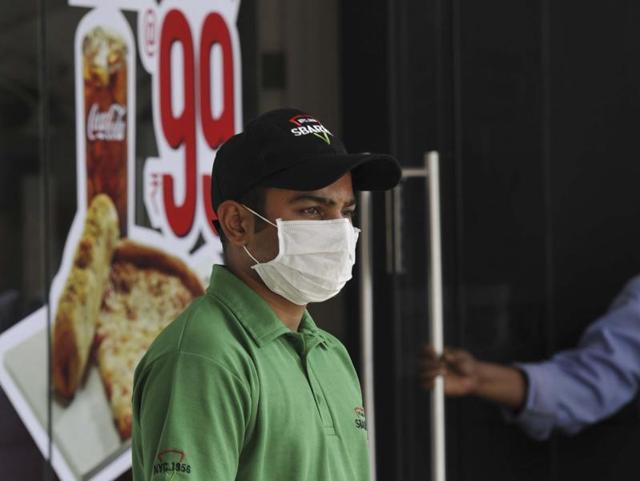 A restaurant worker wearing a mask at work to protect himself from air pollution in Connaught Place. (Saumya Khandelwal/ Hindustan Times)