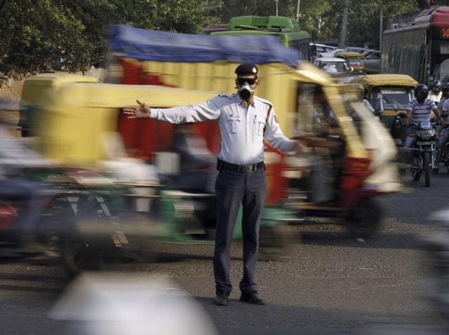 Delhi traffic cop regulating afternoon traffic wearing mask and anti-UV glasses in Tis Hajari. (Photo by Arun Sharma / Hindustan Times)