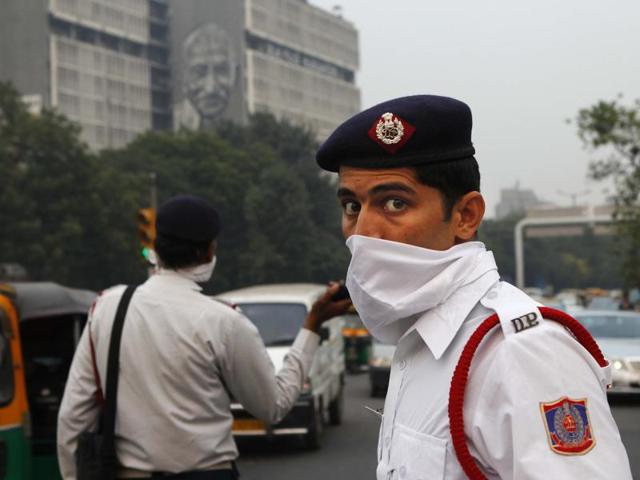 Delhi traffic police personnel cover their faces as a precaution against heavy air pollution at ITO crossing. (Photo by Arvind Yadav/ Hindustan Times)