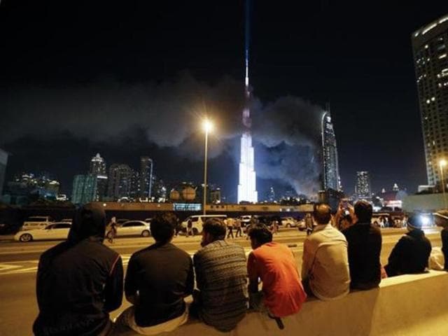 People watch as flames rip through the Address Downtown hotel.  (AFP) 