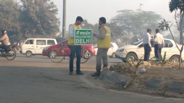 Two volunteers hold a placard waging a war against pollution in the national capital. (Mallica Joshi/ HT Photo) Two volunteers hold a placard waging a war against pollution in the national capital. (Mallica Joshi/ HT Photo)