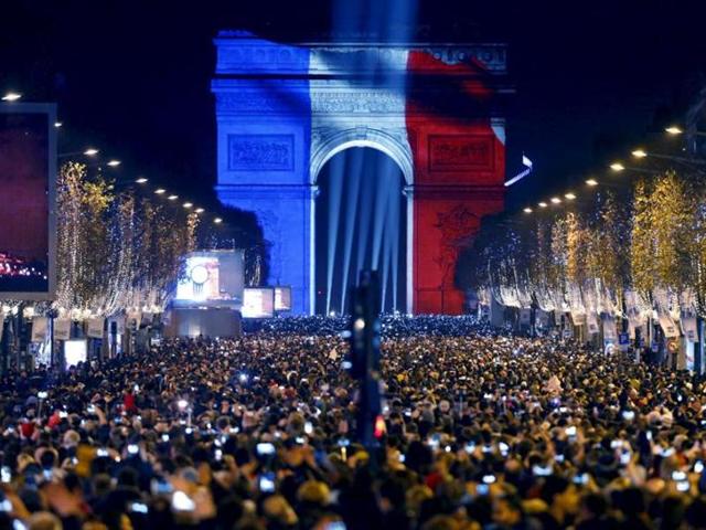 Revellers gather near the Arc de Triomphe which was lit with the blue, white and red colours of the French flag on the Champs Elysees Avenue in Paris. (Reuters) Revellers gather near the Arc de Triomphe which was lit with the blue, white and red colours of the French flag on the Champs Elysees Avenue in Paris. (Reuters)