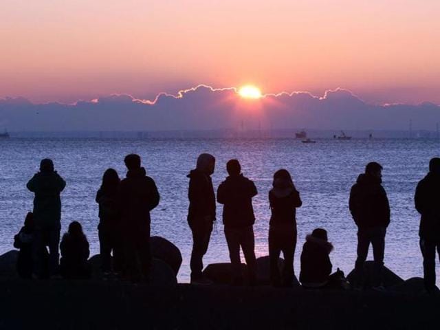 People watch the sun rise on New Year’s Day at a beach along Tokyo Bay. (AFP Photo) People watch the sun rise on New Year’s Day at a beach along Tokyo Bay. (AFP Photo)