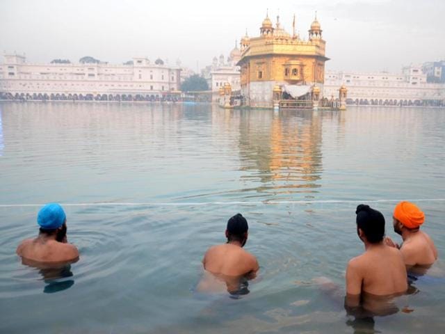 Sikh devotees take bath in the holy sarovar and pay obeisance at Golden Temple, Sikhs' holiest shrine, on the first day of the New Year 2016. (Sameer Sehgal/HT Photo)