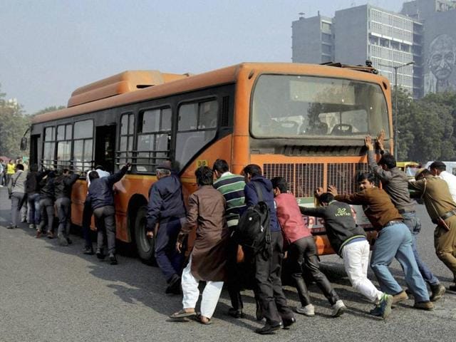 Passengers and traffic policemen push a bus after it broke down at a traffic intersection on the first day of odd-even scheme to fight pollution in New Delhi on Friday. (PTI) Passengers and traffic policemen push a bus after it broke down at a traffic intersection on the first day of odd-even scheme to fight pollution in New Delhi on Friday. (PTI)