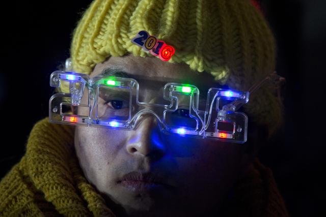 A worker wears mock spectacles in the shape of 2016 during a countdown event in Beijing. (AP) A worker wears mock spectacles in the shape of 2016 during a countdown event in Beijing. (AP)