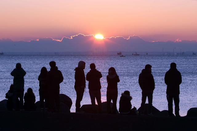 People watch the sun rise on New Year's Day at a beach along Tokyo Bay. (AFP) People watch the sun rise on New Year's Day at a beach along Tokyo Bay. (AFP)