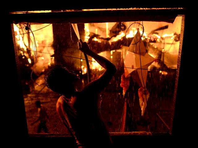 A resident jumps as a fire engulfs houses at a poor neighborhood of Tondo in Manila. (AP Photo) A resident jumps as a fire engulfs houses at a poor neighborhood of Tondo in Manila. (AP Photo)