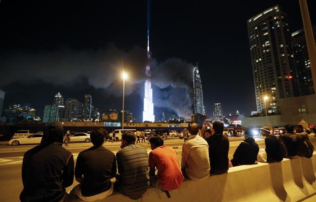 People watch as flames rip through the Address Downtown hotel. (AFP Photo) People watch as flames rip through the Address Downtown hotel. (AFP Photo)