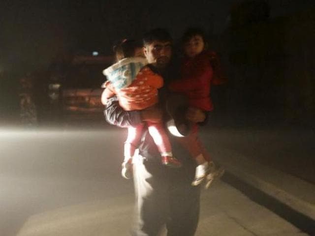 A man carries his children to a safe area from the site of an explosion in Kabul, Afghanistan January 1, 2016 (Reuters) A man carries his children to a safe area from the site of an explosion in Kabul, Afghanistan January 1, 2016 (Reuters)