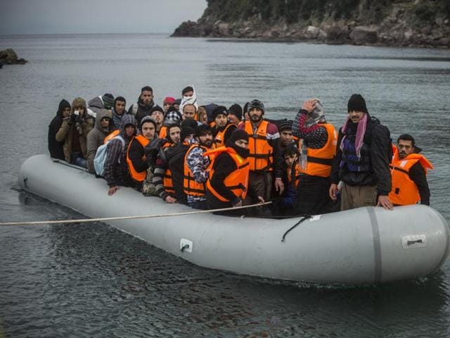 Refugees and migrants onboard a dinghy arrive at the village of Skala, on the Greek island of Lesbos, after crossing the Aegean sea from Turkey, Saturday, Jan. 2, 2016. (AP) Refugees and migrants onboard a dinghy arrive at the village of Skala, on the Greek island of Lesbos, after crossing the Aegean sea from Turkey, Saturday, Jan. 2, 2016. (AP)
