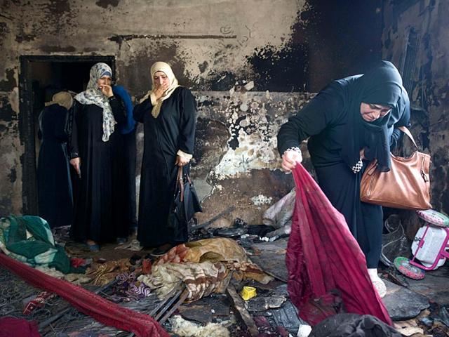 Palestinian women look at the damage at the Dawabsha family's home in the West Bank village of Duma. Israel on Sunday indicted two extremists with the murder of Dawabsha couple and their child. (AFP File Photo) Palestinian women look at the damage at the Dawabsha family's home in the West Bank village of Duma. Israel on Sunday indicted two extremists with the murder of Dawabsha couple and their child. (AFP File Photo)