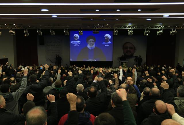 Hezbollah supporters raise their hands as their leader, Sheik Hassan Nasrallah, speaks via a video link. Nasrullah strongly condemned Saudi Arabia for executing Shia cleric Nimr al-Nimr along with 46 others. (AP Photo)