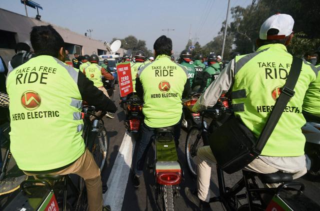 Volunteers offer free rides on e-bikes. As per estimates, about one million private cars are expected to go off the road if the scheme, with the exemptions, tastes success on a regular day. (PTI) Volunteers offer free rides on e-bikes. As per estimates, about one million private cars are expected to go off the road if the scheme, with the exemptions, tastes success on a regular day. (PTI)