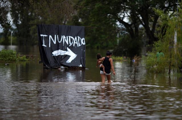 A woman carries her baby through a flooded area of Concordia, Entre Rios province, Argentina, on December 29, 2015. Over recent days the storms blamed on El Nino have killed people in Brazil and in Argentina. Officials say rainfall has driven at least 160,000 people from their homes in Paraguay, Argentina and Uruguay. (AFP) A woman carries her baby through a flooded area of Concordia, Entre Rios province, Argentina, on December 29, 2015. Over recent days the storms blamed on El Nino have killed people in Brazil and in Argentina. Officials say rainfall has driven at least 160,000 people from their homes in Paraguay, Argentina and Uruguay. (AFP)