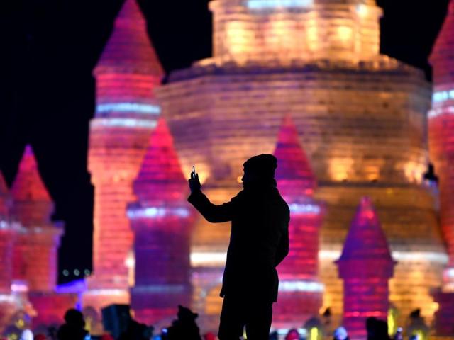 A man takes a photo in front of ice sculptures at the China Ice and Snow World on eve of the opening ceremony of the festival. (AFP) A man takes a photo in front of ice sculptures at the China Ice and Snow World on eve of the opening ceremony of the festival. (AFP)