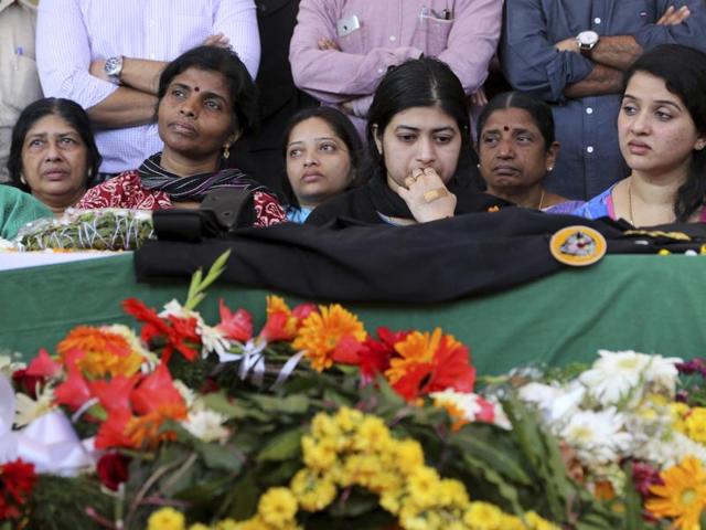 Radhika, center looks at the coffin of her husband and National Security Guard commando, Niranjan Kumar, who was among those killed in the attack on the Pathankot air force base after the body was brought to Bangalore. (AP)