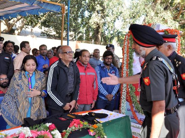 General Officer Commanding, Karantaka and Kerala Sub Area, Major General KS Nijjar (2R) extends his hand to EK Sivaranjam (2L), father of slain lieutenant colonel Niranjan Kumar- (AFP)