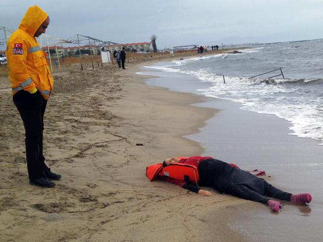 A Turkish rescuer looks at the body of a migrant lying on the beach in Ayvalik, Turkey on Tuesday. Many migrants’ bodies, including of some children, were washed ashore Turkey in the latest tragedy of boat capsizing in the Aegean sea. (AP) A Turkish rescuer looks at the body of a migrant lying on the beach in Ayvalik, Turkey on Tuesday. Many migrants’ bodies, including of some children, were washed ashore Turkey in the latest tragedy of boat capsizing in the Aegean sea. (AP)