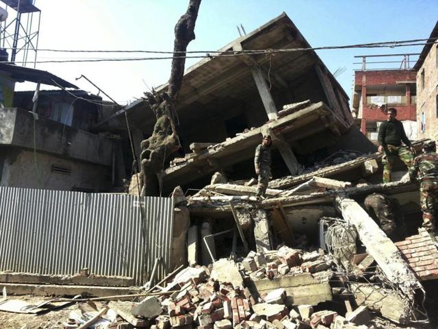 Soldiers inspect a house that collapsed in an earthquake in Imphal.(AP) Soldiers inspect a house that collapsed in an earthquake in Imphal.(AP)