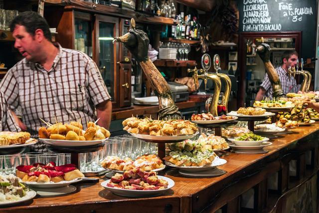 View of a bar with traditional pinchos in San Sebastian, Basque Country, Spain. Pinchos (Pintxos) are traditional appetizer in Basque country. (Shutterstock) View of a bar with traditional pinchos in San Sebastian, Basque Country, Spain. Pinchos (Pintxos) are traditional appetizer in Basque country. (Shutterstock)