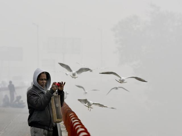 A man clicks pictures amid dense fog in Delhi on Friday morning. (Ravi Choudhary/HT photo)