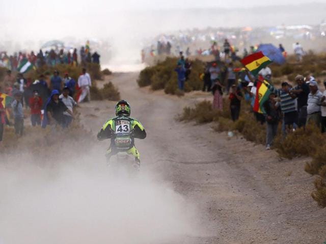 Spectators watch Kawasaki rider Patricio Cabrera, of Chile, race in the rally between the cities of Jujuy, Argentina and Uyuni, Bolivia. (AP Photo)