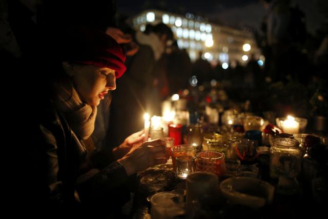 A woman lights a candle as people gather on the Place de la Republique square to pay tribute to the victims of last year's shooting at the French satirical newspaper Charlie Hebdo, in Paris, France, January 7, 2016. (REUTERS Photo) A woman lights a candle as people gather on the Place de la Republique square to pay tribute to the victims of last year's shooting at the French satirical newspaper Charlie Hebdo, in Paris, France, January 7, 2016. (REUTERS Photo)