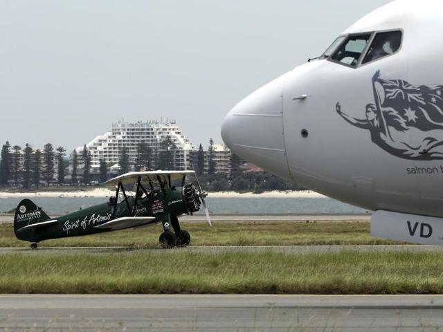 Curtis-Taylor’s 1942 Boeing Stearman Spirit of Artemis taxiing past a modern airliner after she arrived at Sydney Airport. (AP) Curtis-Taylor’s 1942 Boeing Stearman Spirit of Artemis taxiing past a modern airliner after she arrived at Sydney Airport. (AP)