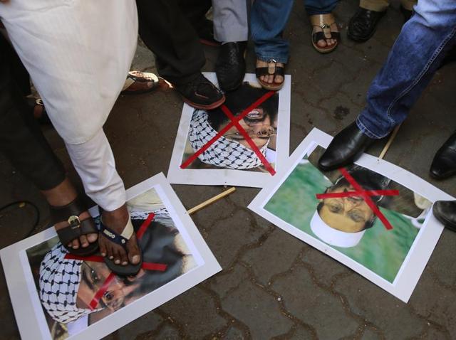 Protestors stamp placards with pictures of Pakistani militant leader Masood Azhar, left and Jamaat-ud-Daawah chief Hafiz Muhammad Saeed as they condemn the attack on the Pathankot air force base in Mumbai.(AP)