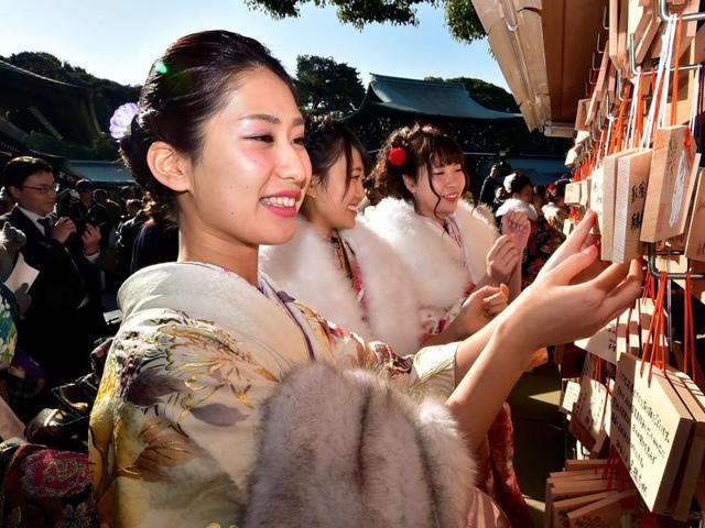 Female tour guides dressed in traditional kimonos hang 'ema', or votive tablets, with their written wishes at the Meiji shrine after attending a purification ceremony. (AFP) Female tour guides dressed in traditional kimonos hang 'ema', or votive tablets, with their written wishes at the Meiji shrine after attending a purification ceremony. (AFP)