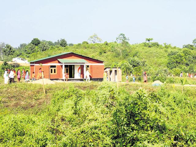 Villagers examine their new homes in New Ram Terang. The first-of-its-kind shift has been a joint effort led by NGOs and the state and local governments.(Subhamoy Bhattacharjee/WTI)