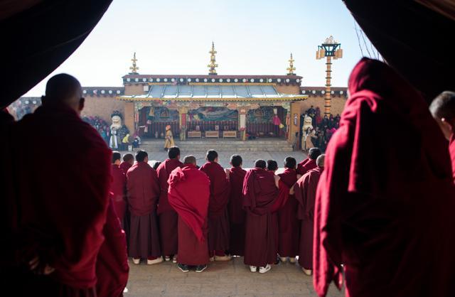 This picture taken at the Ganden Sumtsenling Monastery in Shangri-La, Diqing Tibetan Autonomous Prefecture of southwest China's Yunnan Province, shows old and young lamas watching the Cham dance during the Gedong festival. (AFP)