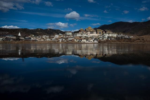 The Ganden Sumtsenling Monastery is reflected in a lake in Shangri-La. The Ganden Sumtseling Monastery also known as Songzanlin and Guihuasi, is the largest Tibetan Buddhist monastery in Yunnan. (AFP)