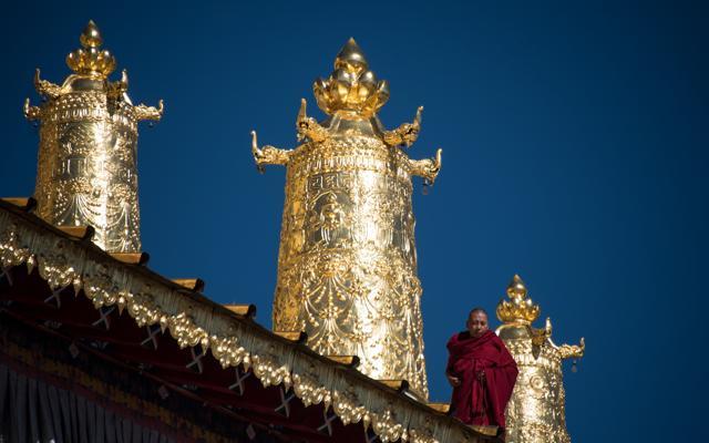 A lama stands on the roof of the Ganden Sumtsenling Monastery in Shangri-La. The Gedong Festival is the most important festival in the region and is held at the Ganden Sumtseling Monastery, also known as Songzanlin, and Guihuasi monastery in late November of each year of the Tibetan calendar. The Cham Dance is the climax, as performers put on masks and clothes that portray deities and ghosts. (AFP)
