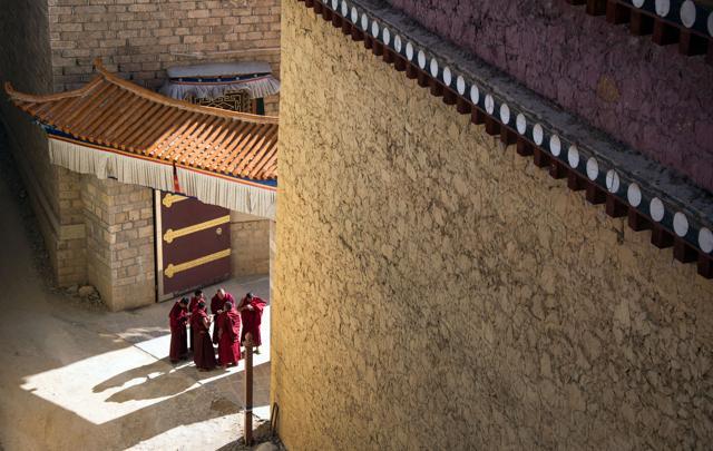 Lamas chat in the sun at the Ganden Sumtsenling Monastery in Shangri-La. (AFP)