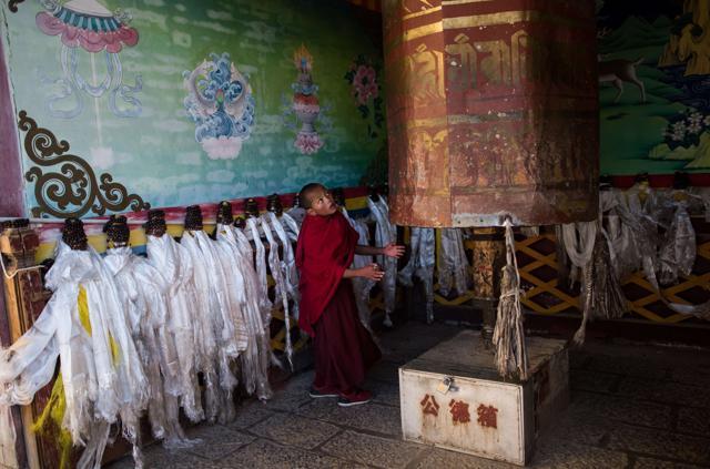 A young lamas turns a prayer wheel at the Ganden Sumtsenling Monastery in Shangri-La. (AFP)