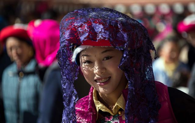 A young girl in traditional Tibetan clothes watches the Cham dance during the Gedong festival. (AFP)