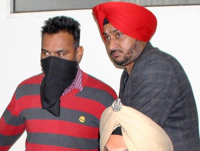 Prem Singh (face covered) was arrested from his native place in Tarn Taran when he was on leave. He was posted as a head constable with the 72 Battalian of BSF in Barmer in Rajasthan. (HT Photo) Prem Singh (face covered) was arrested from his native place in Tarn Taran when he was on leave. He was posted as a head constable with the 72 Battalian of BSF in Barmer in Rajasthan. (HT Photo)