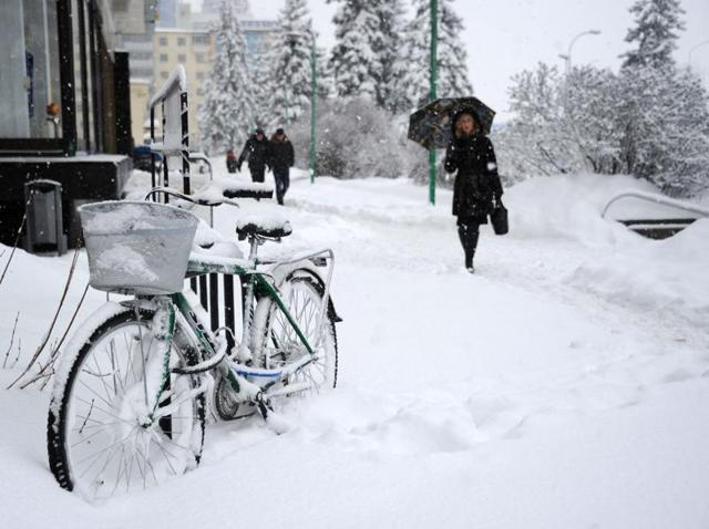 People walk past a snow-covered bicycle in Minsk. So beautiful, it is worthy of being made a desktop wallpaper. (AFP)