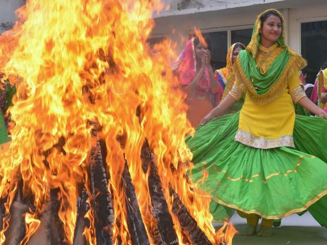 College women clad in traditional Punjabi dress performing 'giddha' (folk dance) around a bonfire during Lohri celebrations in Amritsar. (AFP Photo)