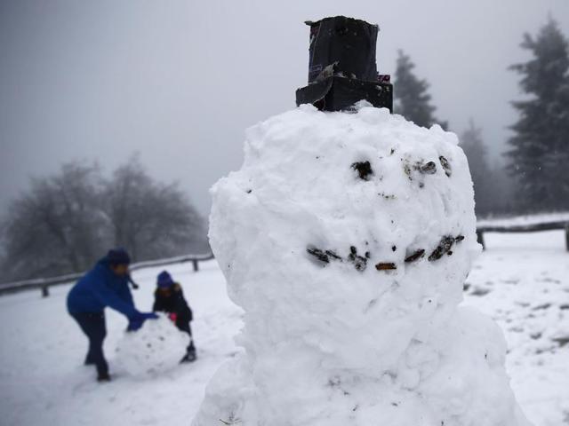 A family builds snowmen during this winter's first snow on top of the Feldberg mountain, 20km west of Frankfurt, Germany. (REUTERS)