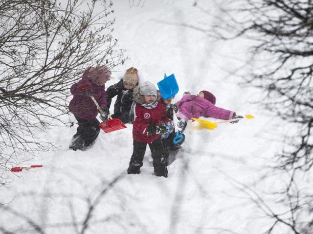 Children play with snow in a kindergarten in Moscow, Russia. The one in pink seems to be making snow angels. (AP)